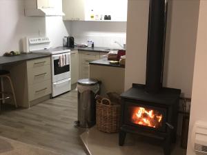 a kitchen with a stove with a fire in it at Baybell Lodge in Tauranga