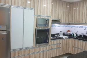 a kitchen with a stove and a microwave in it at A melhor vista de Santos para 5 pessoas pé na areia in Santos