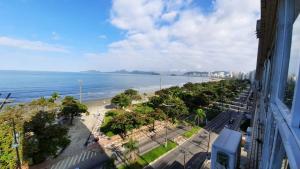 uma vista para a praia e para o oceano a partir de um edifício em A melhor vista de Santos para 5 pessoas pé na areia em Santos