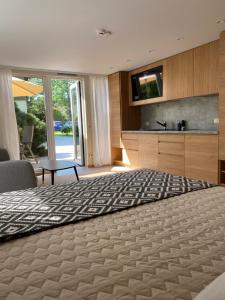 a large bedroom with a large bed and a television at Sodyba prie jūros in Palanga