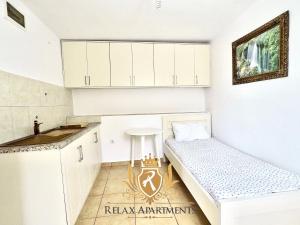 eine Küche mit weißen Schränken und einer Bank in einem Zimmer in der Unterkunft Paradise Palm Beach Apartment in Sarande in Sarandë