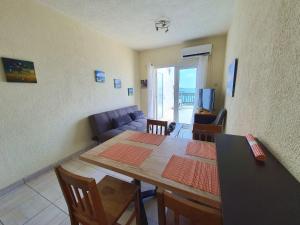 uma sala de estar com uma mesa e um sofá em Poseidon 51 - Beachfront Two Bedroom Apartment em Pafos