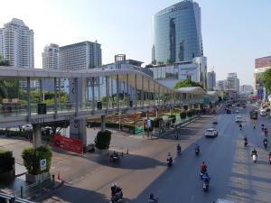 a busy city street with cars and motorcycles and buildings at Pratunam19 Hotel in Bangkok