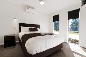 a bedroom with a large bed and a large window at Moama Waters in Moama