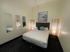 a hotel room with two beds and a lamp at Rooms at Carboni's in Ballarat