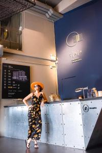 a woman standing next to a counter in a restaurant at THA City Loft by TH District in Bangkok
