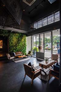 a living room with a couch and a chair at THA City Loft Hotel by TH District in Bangkok