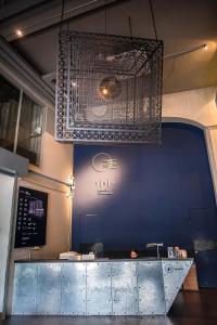 a kitchen with a blue wall and a chandelier at THA City Loft Hotel by TH District in Bangkok