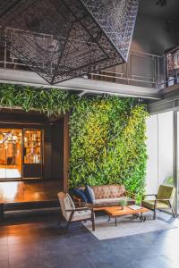 a living room filled with furniture next to a tree at THA City Loft Hotel by TH District in Bangkok