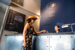 a woman standing at a counter in a restaurant at THA City Loft Hotel by TH District in Bangkok