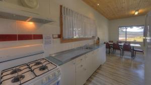 a kitchen with a stove top oven and a refrigerator at Anglers Reach Lakeside Village in Anglers Reach