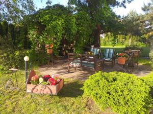 un jardín con banco, mesa y sillas en Guest House Pechersky & Sons en Dreiliņi
