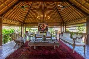 a pavilion with a chandelier and a table and chairs at Villa Angsa by Nakula in Sanur