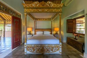 a bedroom with a canopy bed in a room at Villa Angsa by Nakula in Sanur