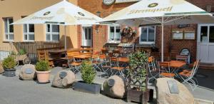 a restaurant with tables and chairs under an umbrella at Gasthof zum alten Schulmeister in Harra