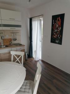 Habitación blanca con cocina, cama blanca y mesa en Lino Apartments, en Rovinj