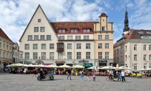 a group of people standing in front of a large building at Tallinn City Apartments Old Town Square in Tallinn