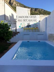 una piscina de agua azul frente a un edificio en Casa Baraka, en Algodonales