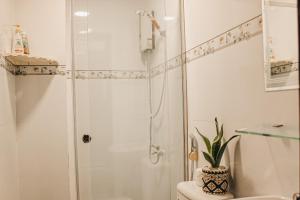 a white bathroom with a shower and a toilet at NGOC LINH MOTEL in áº¤p VÄ©nh ÃÃ´ng