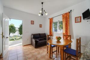 een woonkamer met een tafel en een bank bij Los paraisos 1 in Conil de la Frontera
