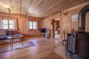 a living room with wooden walls and a stove at Chalet Büdemji by Arosa Holiday in Arosa