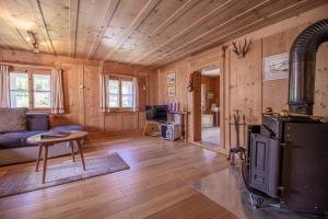 un soggiorno con pareti in legno e stufa di Chalet Büdemji by Arosa Holiday a Arosa