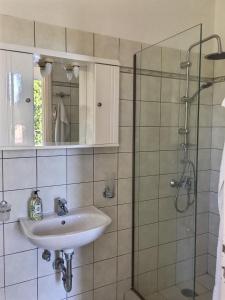a bathroom with a sink and a glass shower at Gastouri Villa Pascalia with heated pool in October and views in Achílleion