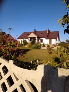 a house with a white fence in front of a yard at Polne Zacisze in Lgiń