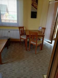 una sala da pranzo con tavolo e sedie di Apartmán Fiona a Veľká Lomnica