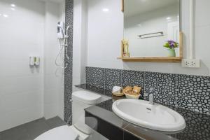 a white bathroom with a sink and a toilet at Otter House in Krabi