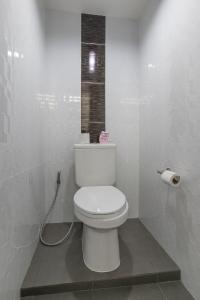 a white bathroom with a toilet in a stall at Otter House in Krabi town