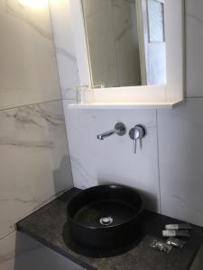 カタポラにあるPension Galiniのバスルーム(黒い洗面台、鏡付)