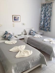 a room with two beds with towels on them at Pension Galini in Katapola
