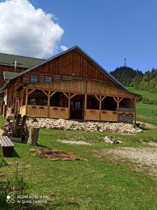 a large wooden barn in a field of grass at Chata Koliba in Stará Ľubovňa