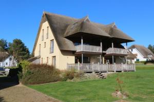 a large house with a thatched roof at Fewos Herrmann Achterwasserblick in Loddin