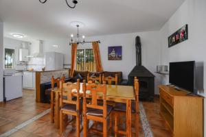 eine Küche und ein Wohnzimmer mit einem Tisch und einem Kamin in der Unterkunft Los paraisos 3 in Conil de la Frontera