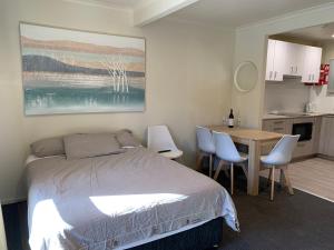 a bedroom with a bed and a table and chairs at Aneeki Ski Lodge in Thredbo