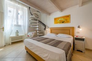 a bedroom with a bed and a spiral staircase at Dimora Grottone in Polignano a Mare