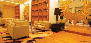 uma sala de estar com sofás e um espelho em Royal Asnof Hotel Pekanbaru em Pekanbaru