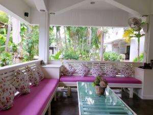 een veranda met paarse en roze kussens en een glazen tafel bij Simple Life Resort Koh Tao in Ko Tao