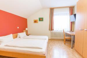 Tempat tidur dalam kamar di Gasthof Jagersberger