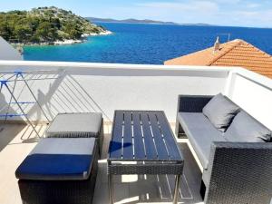 - un balcon avec deux chaises et un banc donnant sur l'océan dans l'établissement Apartman Šime, à Tribunj