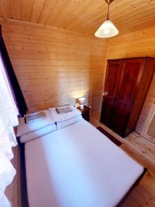 a bedroom with a white bed in a wooden room at ALBATROS Wicie in Wicie
