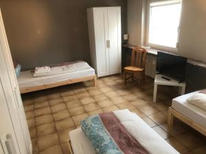 a room with two beds and a desk and a television at Wohnung 4 in Alzenau