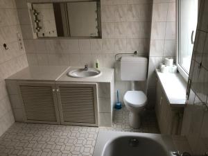 uma casa de banho com um lavatório, um WC e um espelho. em Wohnung 4 em Alzenau in Unterfranken