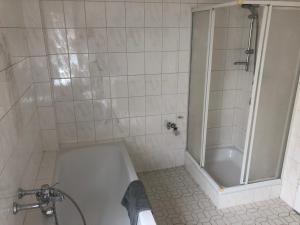 uma casa de banho com um chuveiro e uma banheira branca em Wohnung 4 em Alzenau in Unterfranken