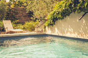 a pool of water next to a wall at CHAMBRES D'HÔTES L'Oréliane en Provence SPA in Châteauneuf-de-Gadagne
