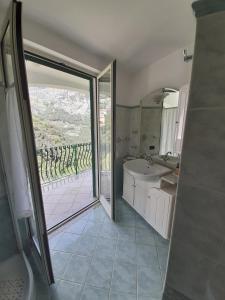 a bathroom with a tub and a sink and a window at Gerry house in Amalfi