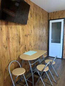 a table and chairs in a room with wooden walls at Мини-отель Sunrise-Bugaz in Zatoka