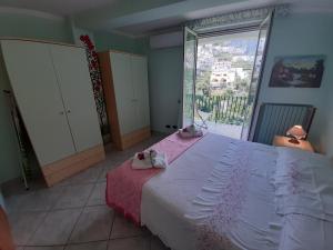 Un dormitorio con una cama grande y una ventana grande. en Gerry house, en Amalfi
